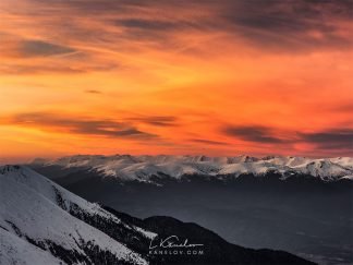 Fire sky over snowy mountains